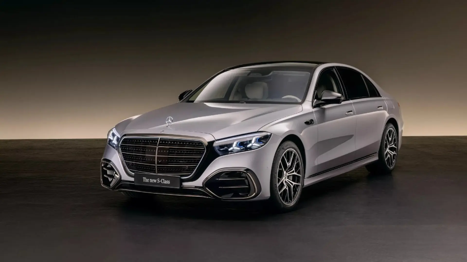 Mercedes Classe S 2026 berline de luxe grise vue de trois-quarts avant avec nouvelle calandre illuminée