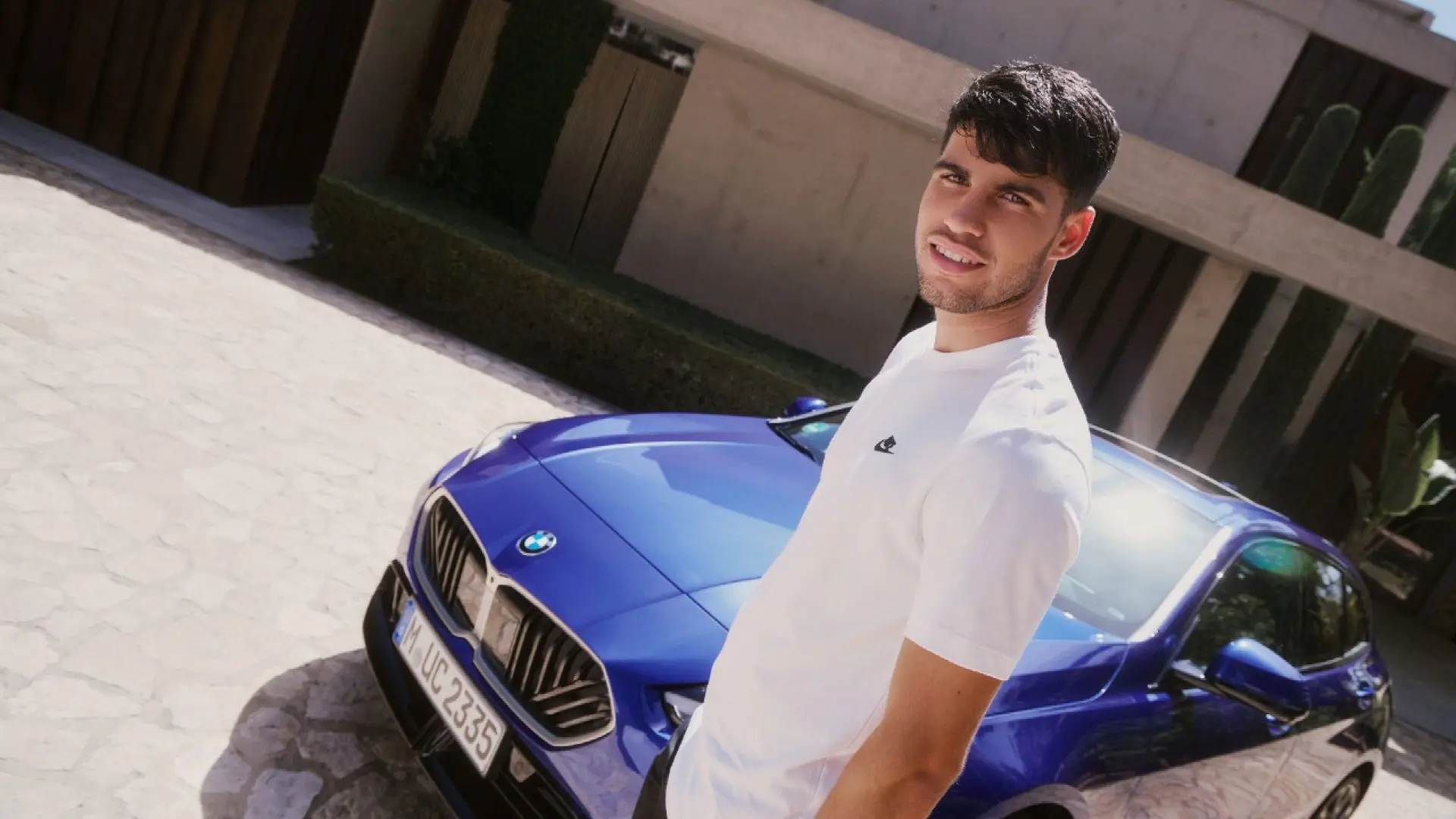 Carlos Alcaraz célèbre sa victoire sur un court de tennis, sponsor BMW visible en arrière-plan