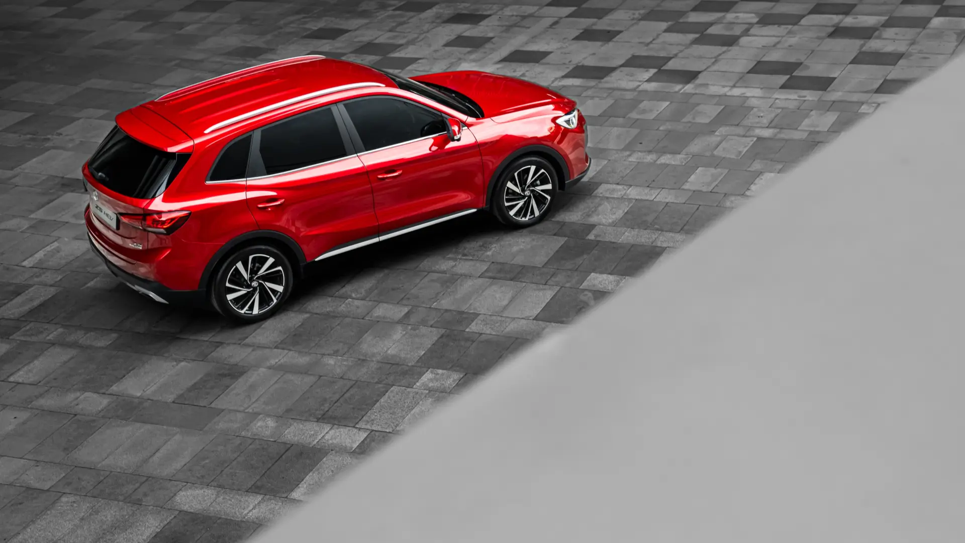 Véhicule électrique MG Motors garé en concession avec panneau promotionnel annonçant compensation de 4500 euros