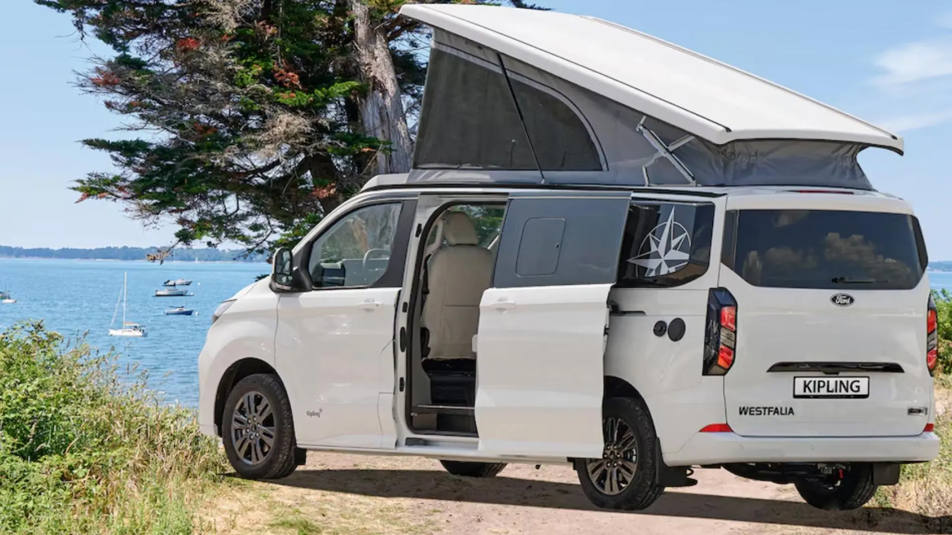 Westfalia Kipling camping-car compact avec extensions latérales déployées montrant le lit fixe transversal