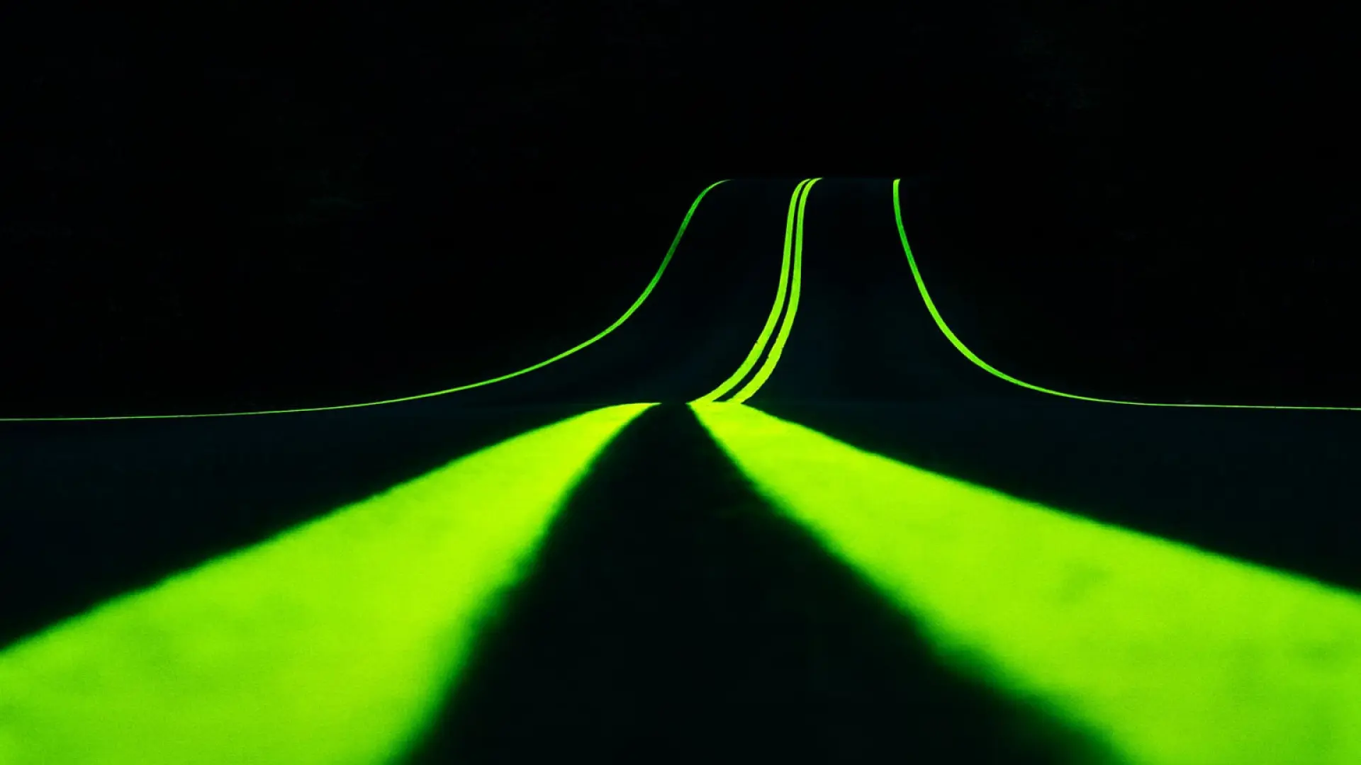 Ligne de marquage routier photoluminescente brillant dans l'obscurité sur une route asphaltée