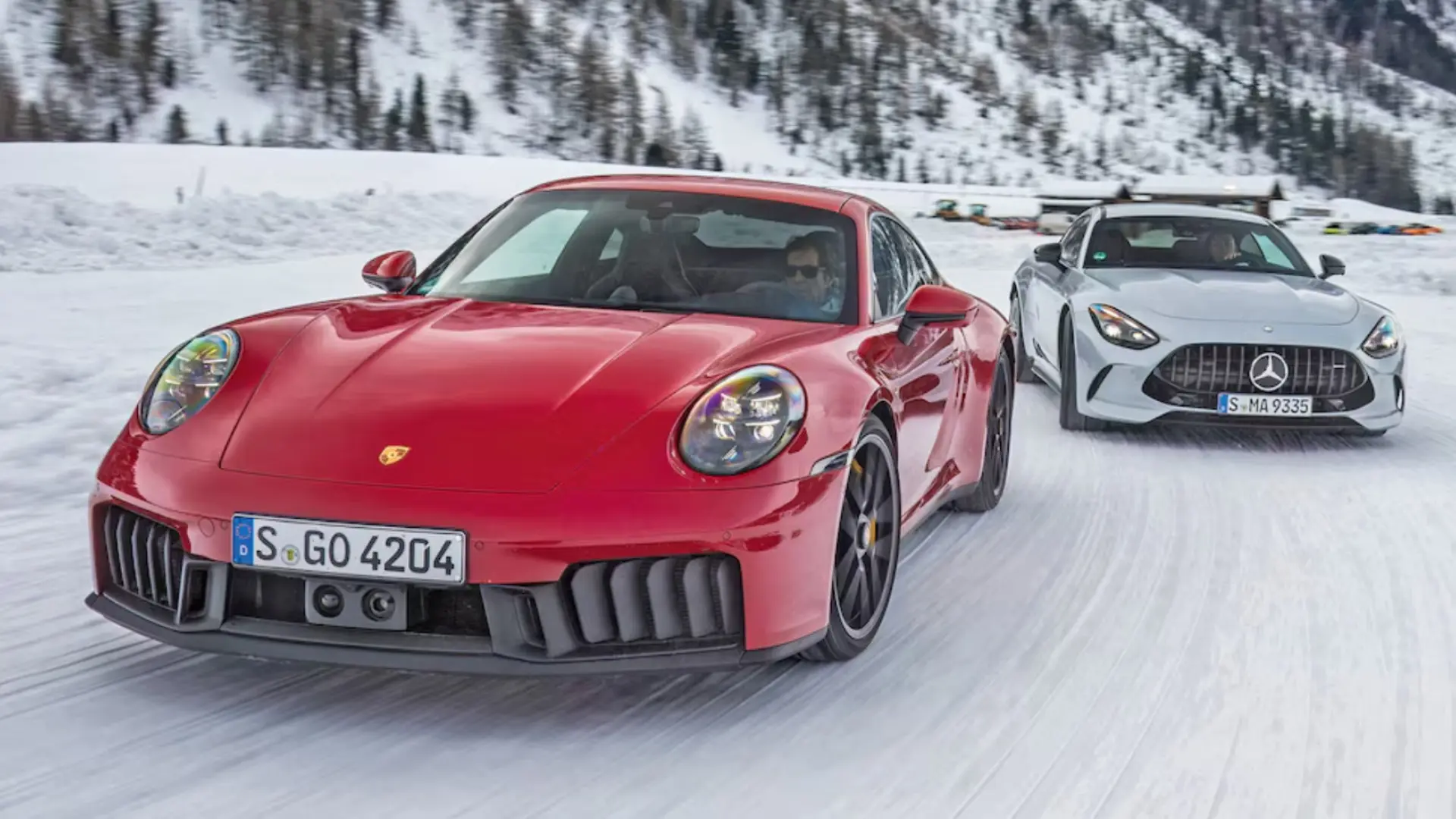 Porsche 911 Carrera 4 GTS hybride et Mercedes-AMG GT 63 côte à côte sur circuit enneigé à Livigno
