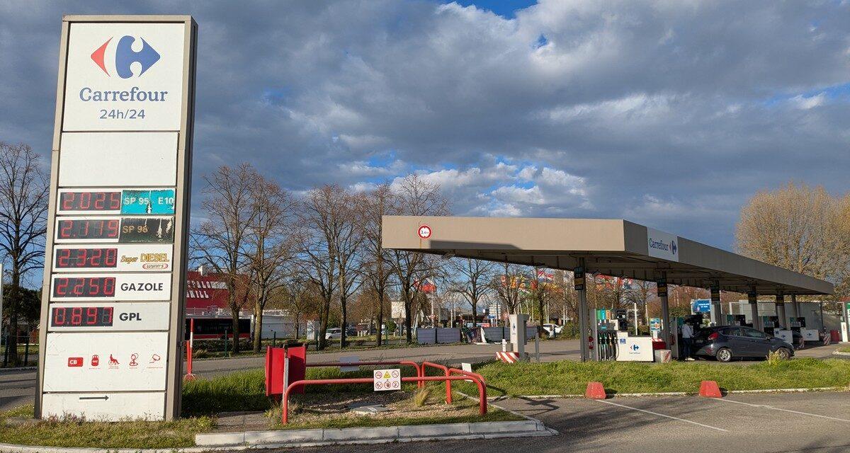 Station-service avec panneau en rupture de carburant et file de voitures en attente